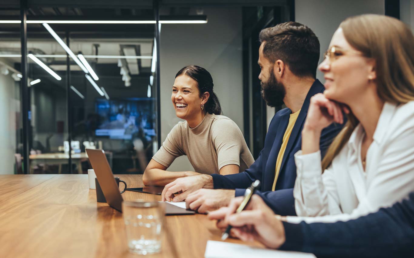 a group of people laughing at a meeting