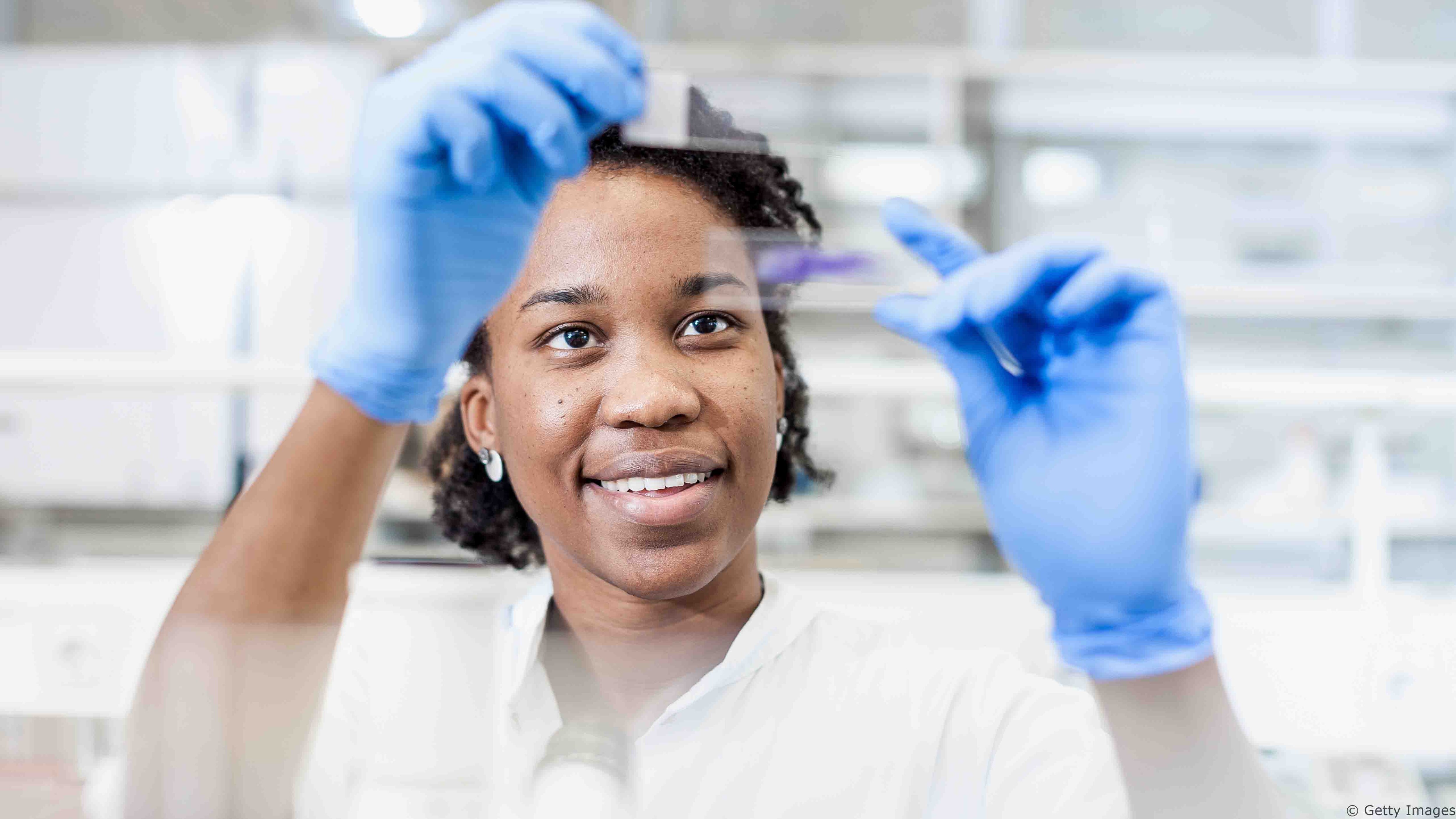 623208264-Scientist Looking at a Microscope Slide