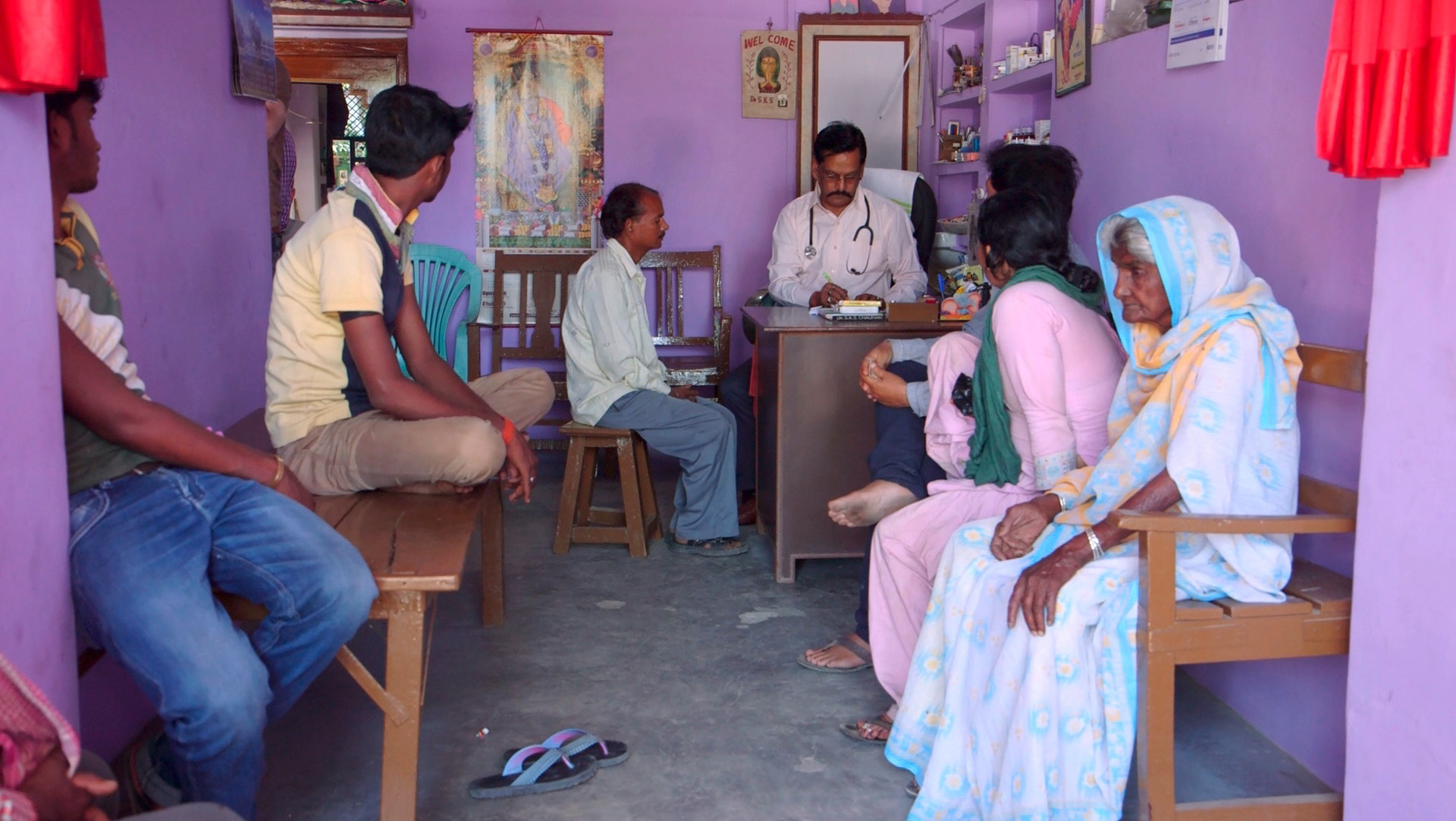 Dr Chauhan’s patients sit on rough wooden benches in the entrance area of his practice.