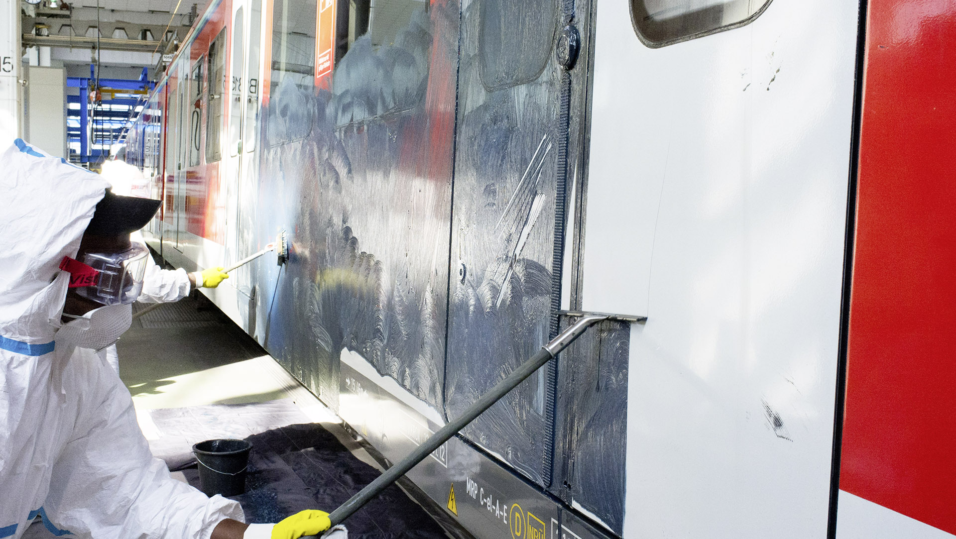 The graffiti cleanser is worked into the paint with brushes and the pasty mixture is then skimmed off with squeegees.