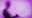   The blurry silhouette of a person writing on a pad seen against a purple background