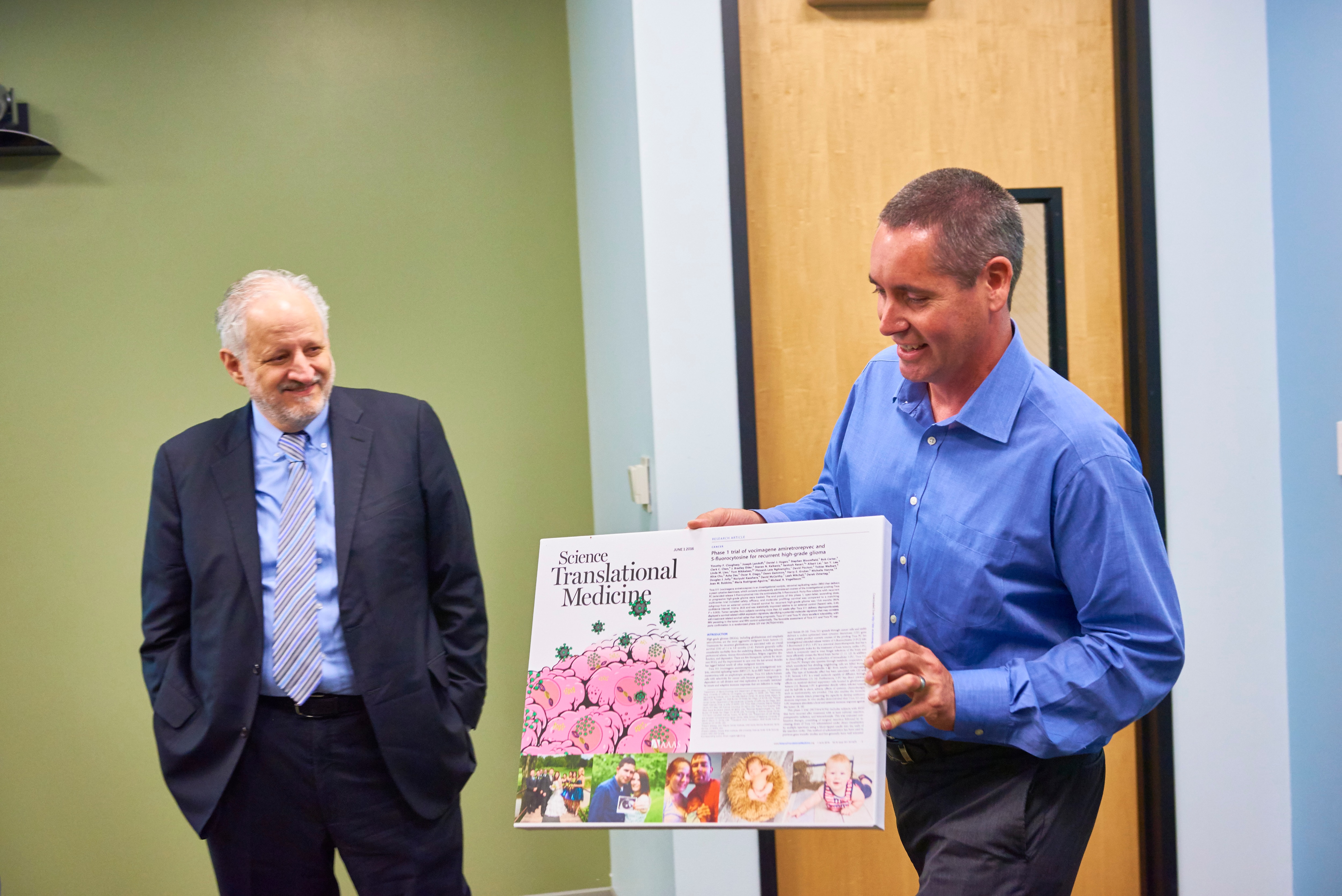 Harry Gruber, MD (left) and Nicholas Boyle, Ph.D. (right) presenting a collage to a patient who visited the company to meet the Tocagen team
